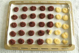 右手拿裱花袋，左手捏裱花嘴，垂直在烤盘上方。匀速挤出曲奇糊，逆时针或者顺时针一圈，尾部轻轻往下压，然后提起收尾！