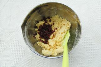 用刮刀切拌往盆边按压的方式，搅拌均匀至没有干粉。倒入蔓越莓碎。