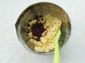 用刮刀切拌往盆边按压的方式，搅拌均匀至没有干粉。倒入蔓越莓碎。