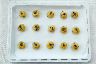 预热烤箱，上下170度。烤盘垫油纸。分成20克一个，搓圆略按平。刷上适量全蛋液，撒上黑芝麻。