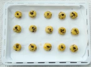 预热烤箱，上下170度。烤盘垫油纸。分成20克一个，搓圆略按平。刷上适量全蛋液，撒上黑芝麻。