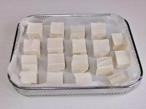 豆腐摆在垫好油纸的烤网中。