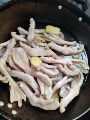 锅中放入适量的水，放入一大勺料酒，姜片，再放入鸭掌焯水两分钟左右！