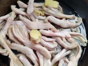 锅中放入适量的水，放入一大勺料酒，姜片，再放入鸭掌焯水两分钟左右！