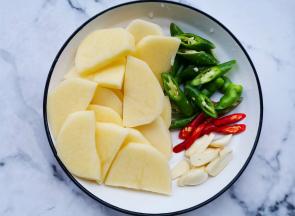 土豆切厚片，辣椒切段，大蒜切片，切好的土豆泡水洗净。