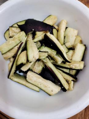 切好的茄子放入容器中，放入一勺盐抓匀稍微给它腌制一下！