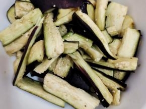 切好的茄子放入容器中，放入一勺盐抓匀稍微给它腌制一下！