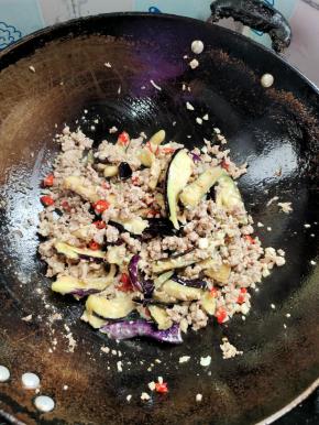 腌制好的茄子捏干水分放进锅里，（这样茄子不容易吸油！）翻炒均匀！