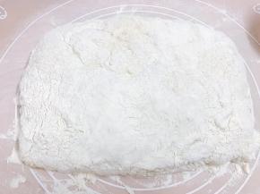 在面团表面同样撒上面粉，把四周用手轻轻归拢一下成方形