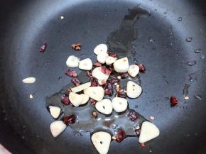 锅里加入适量植物油，加入干辣椒，花椒和蒜片爆香