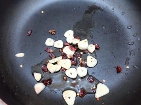 锅里加入适量植物油，加入干辣椒，花椒和蒜片爆香