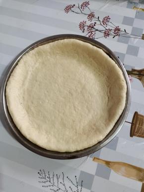 放入披萨饼皮！用手按压一下！整理成边缘厚一点，中间薄的饼皮！