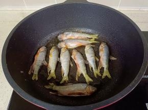 锅里倒入适量的油，油热放入小鱼煎。