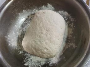 面粉中加入发酵粉，白糖搅拌均匀，再倒入适量的温水搅拌成棉絮状，再揉成光滑细腻的面团！盆里撒少许面粉，把揉好的面团放进盆里！
