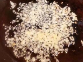 另起锅倒入底油加热放入蒜粒爆香