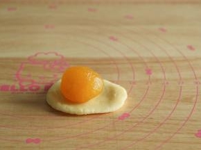 8、花型取18克皮，凤梨形取15克皮。饼皮搓圆放手心，用另一手按压成圆形，放入馅料球。