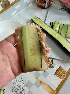 取一块五花肉肉片，再取一片黄瓜放在上面！