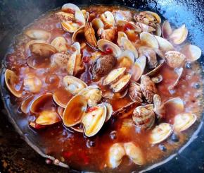 煮好的花甲倒入料汁中均匀的裹上调料汁即可出锅享用