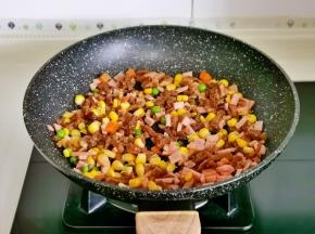 锅中不加油，倒入熟牛肉丁，培根丁，时蔬翻炒2分钟关火。