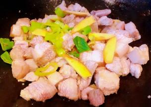 五花肉炒至变色出油放入葱姜炒出香味