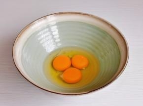鸡蛋磕入碗中。