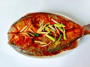 料汁均匀地刷遍整条鲈鱼。