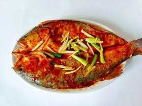 料汁均匀地刷遍整条鲈鱼。