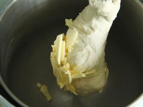 加软化的黄油。转2档让黄油和面团打融合。再转4档打到手套膜阶段。