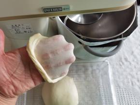 打好面团取出，两手握面团，向身体外侧折叠收圆，切一块慢慢扯开就能看到薄而结实的手套膜。