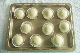 撕开保鲜袋，取下酥皮，放上滚圆的面团，光滑面接触酥皮。然后将酥皮贴合到面团底部，略收紧即可。放入圆形油淋模具中，排入烤盘。