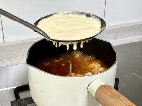 把面糊舀入漏勺，面上总勺子或刮刀按压，让面糊均匀地落到沸水中，这样做出来的面疙瘩大小均匀，好看又好吃