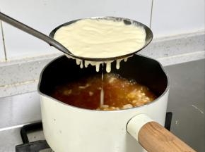 把面糊舀入漏勺，面上总勺子或刮刀按压，让面糊均匀地落到沸水中，这样做出来的面疙瘩大小均匀，好看又好吃