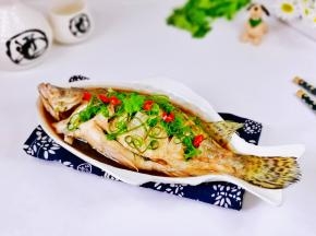 取出蒸好的鱼，淋上热油，撒上葱丝点缀辣椒段。