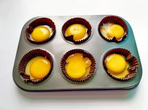 每个纸杯磕入一个鸡蛋。