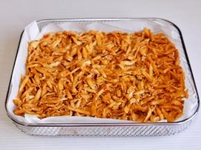 炸网上垫油纸，铺上杏鲍菇丝。