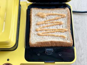 把吐司片放入三明治机，挤上千岛酱（或别的你喜欢的酱料）