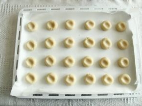 预热烤箱，上下180度。带PVC手套，分团15克一个，搓圆排列在垫了油纸的烤盘上，用大拇指从中间轻轻按扁。