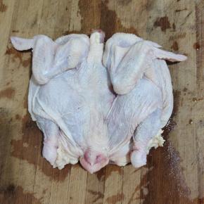 三黄鸡里里外外清洗干净，剪去鸡爪和鸡头！放到案板上面，稍微按一下，左右掰一下尽量撑开！这样可以省油也能炸透！