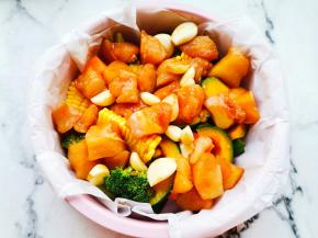 将所有时蔬放入烤盘上，铺上鸡胸肉，