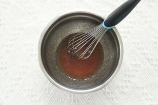 花生油、转化糖浆、枧水倒入干净盆中。，用手动打蛋器搅打均匀。