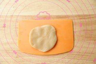 全程带PVC手套。把饼皮搓圆，放在左手掌心，用右手掌心按压成薄薄的圆形，