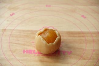 放上馅料球，翻转，馅料球在下，饼皮在上，让饼皮贴合到馅料球上，再翻转。