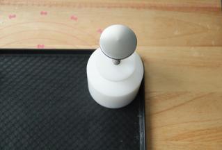 预热烤箱，上下220度，预热时间一定要够。把月饼球放入加好花片的模具中，放置在烤盘上，用力均匀压2下。