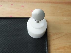 预热烤箱，上下220度，预热时间一定要够。把月饼球放入加好花片的模具中，放置在烤盘上，用力均匀压2下。