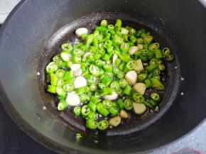 锅中热油，爆香蒜片，加入青椒炒香，