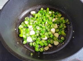 锅中热油，爆香蒜片，加入青椒炒香，