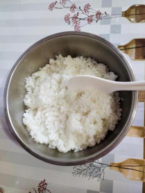 蒸熟的米饭趁热把它倒进容器里，用饭铲把它打散！这样米饭才会粒粒分明！