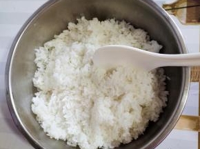 蒸熟的米饭趁热把它倒进容器里，用饭铲把它打散！这样米饭才会粒粒分明！