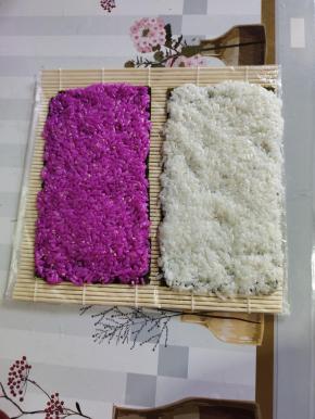 分别把白色米饭和红色米饭均匀的平铺在海苔上！按压紧实！