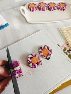 找一把锋利的刀，手轻轻的扶在寿司上，把两头切掉自己吃，中间的部分切成均匀的小段儿！